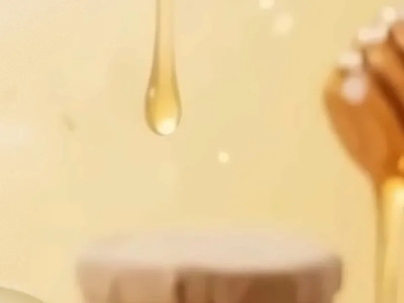 Honey dripping from a wooden dipper